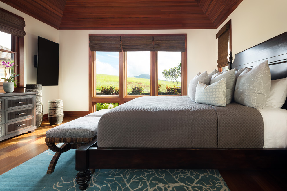 ハワイにある中くらいなトロピカルスタイルのおしゃれな客用寝室 (白い壁、無垢フローリング、茶色い床、暖炉なし、グレーとブラウン) のインテリア