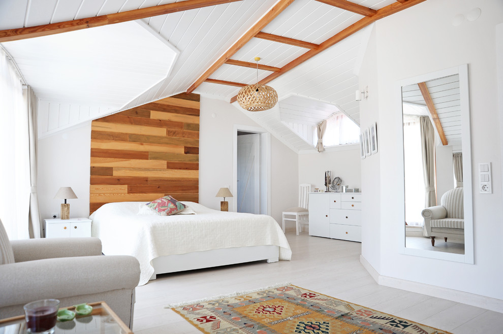 Modelo de dormitorio principal campestre con paredes blancas, suelo de madera clara y suelo gris