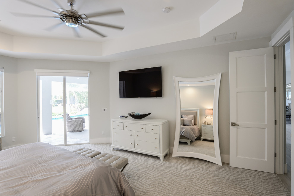 Ejemplo de dormitorio principal actual de tamaño medio sin chimenea con paredes grises, moqueta y suelo beige