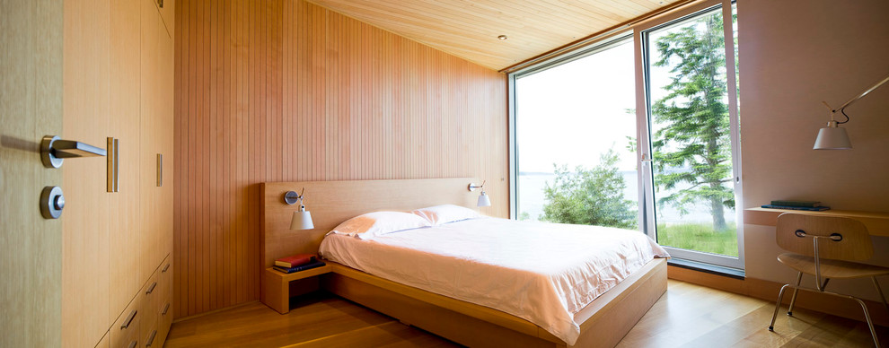 Modelo de dormitorio principal moderno de tamaño medio sin chimenea con paredes beige, suelo de madera en tonos medios y suelo marrón