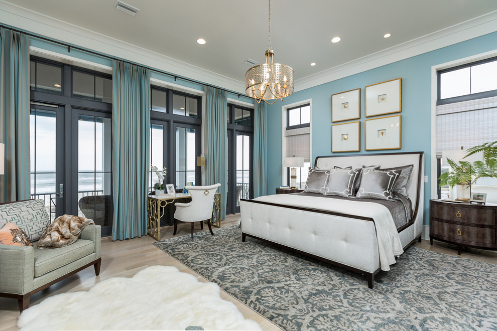 マイアミにある広いトランジショナルスタイルのおしゃれな主寝室 (青い壁、淡色無垢フローリング、暖炉なし) のインテリア