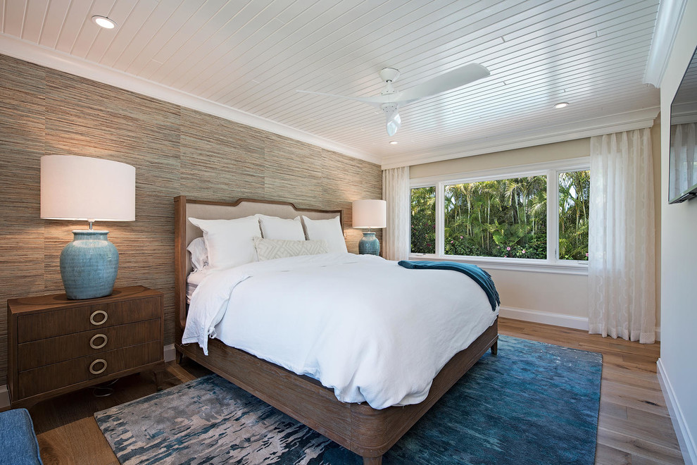 Immagine di una camera da letto tropicale con pareti beige, parquet chiaro e nessun camino
