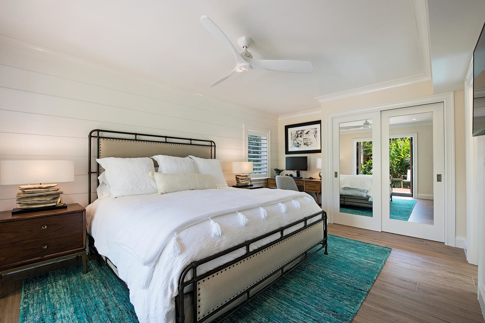 Schlafzimmer ohne Kamin mit weißer Wandfarbe und braunem Boden in Miami
