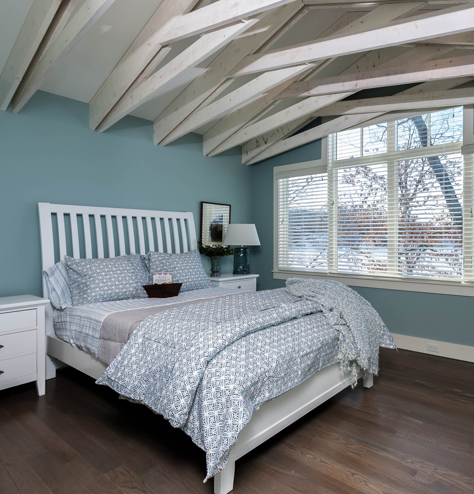Aménagement d'une chambre d'amis classique de taille moyenne avec un mur bleu et un sol en bois brun.