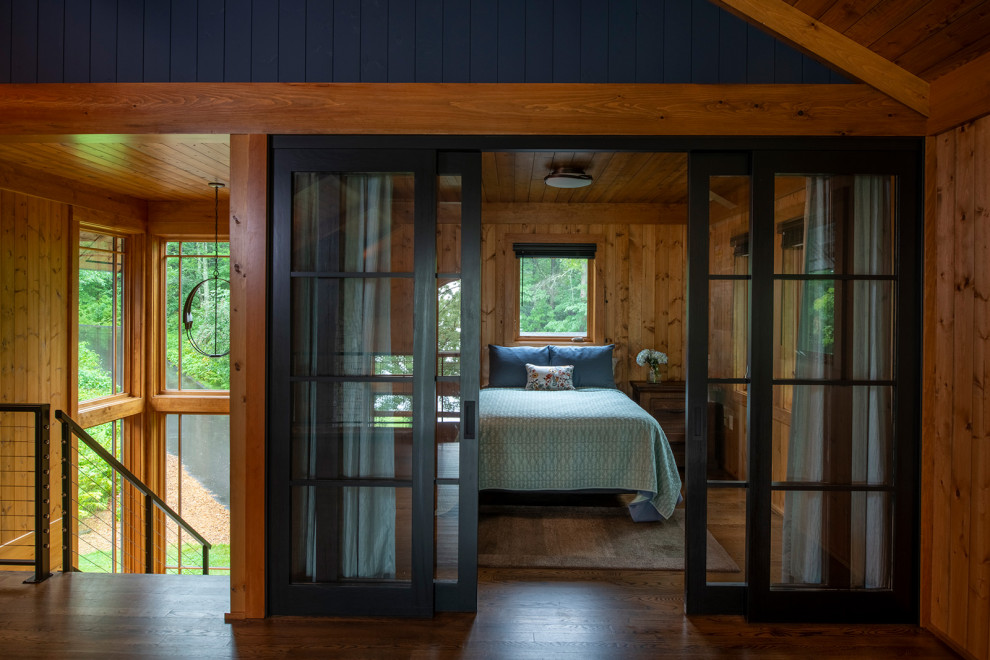 Aménagement d'une chambre montagne en bois avec un mur marron, parquet foncé, un sol marron et un plafond en bois.