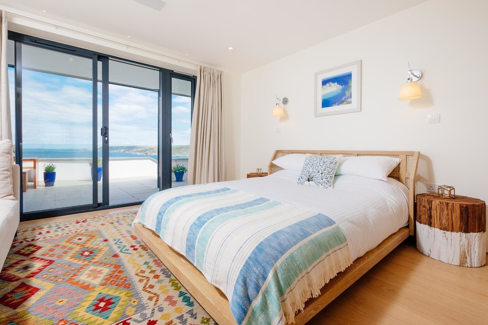 Maritimes Schlafzimmer mit weißer Wandfarbe und braunem Holzboden in Cornwall