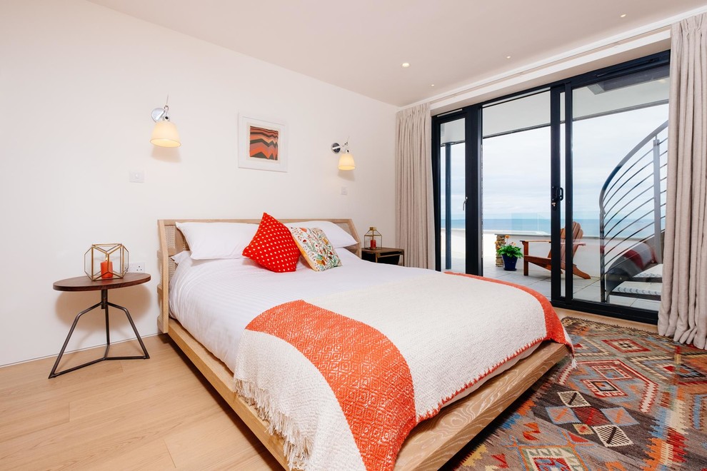 Maritimes Schlafzimmer mit weißer Wandfarbe und hellem Holzboden in Cornwall