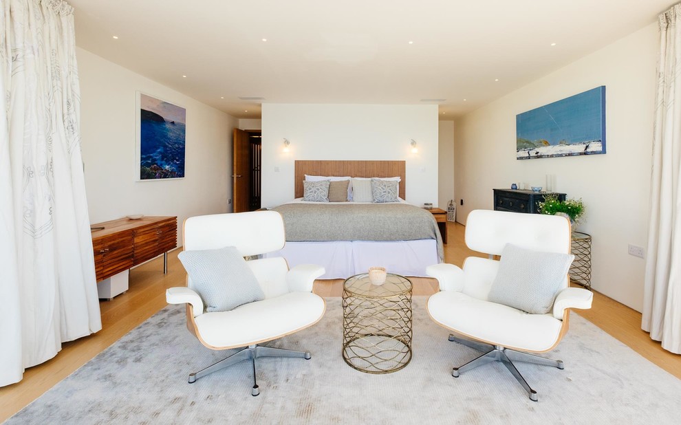 Diseño de dormitorio costero con paredes blancas y suelo de madera en tonos medios