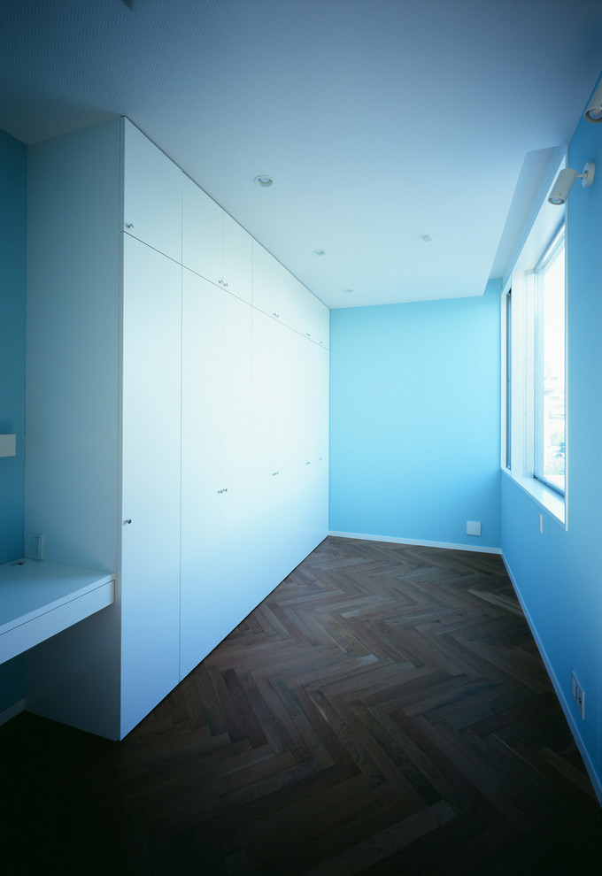 Idéer för ett modernt sovrum, med blå väggar och mellanmörkt trägolv
