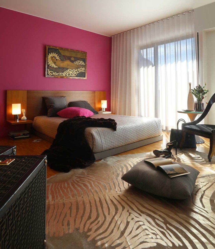 Réalisation d'une chambre parentale design de taille moyenne avec un mur rose et un sol en bois brun.