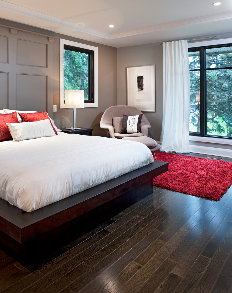Modelo de dormitorio contemporáneo con suelo de madera oscura y paredes grises