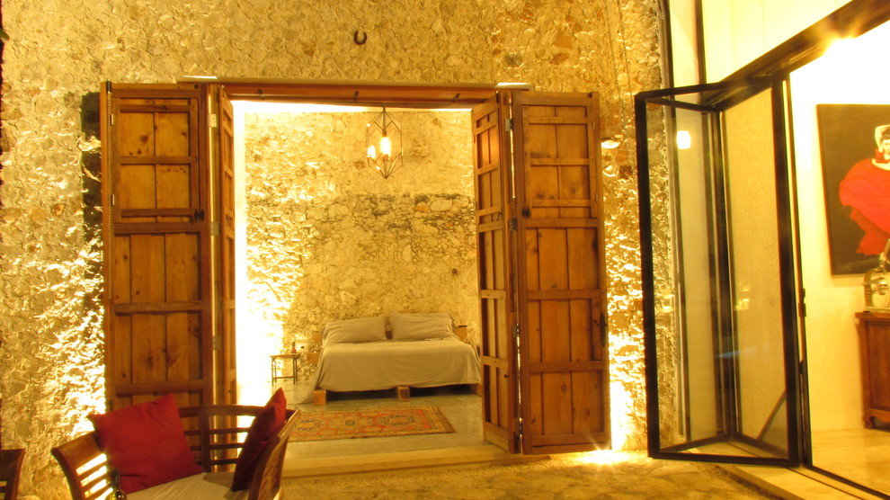 Cette photo montre une grande chambre parentale exotique avec sol en béton ciré et aucune cheminée.