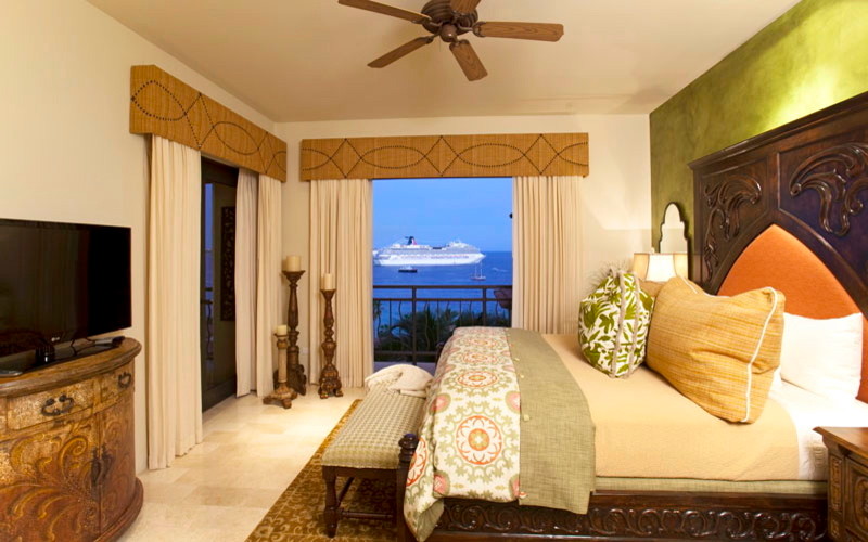 На фото: большая хозяйская спальня в средиземноморском стиле с бежевыми стенами и полом из травертина без камина
