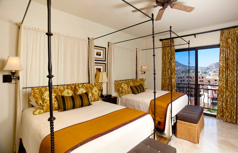 На фото: большая гостевая спальня (комната для гостей) в средиземноморском стиле с бежевыми стенами и полом из травертина без камина