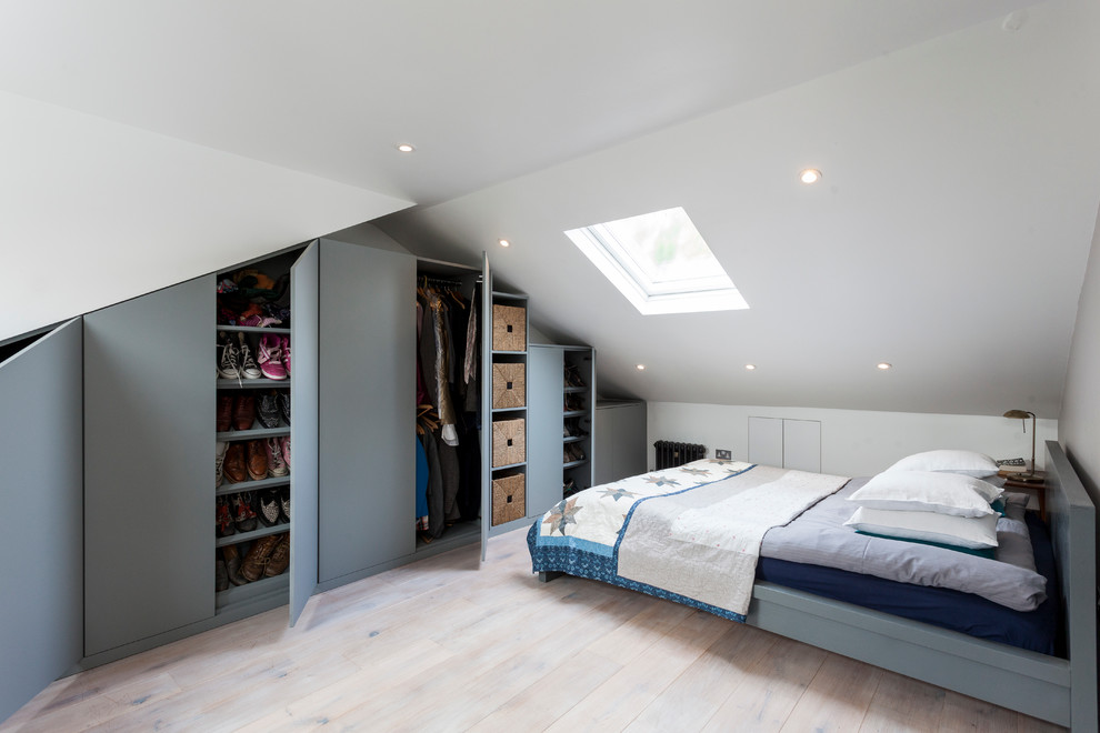 ロンドンにある北欧スタイルのおしゃれな客用寝室 (白い壁、淡色無垢フローリング)