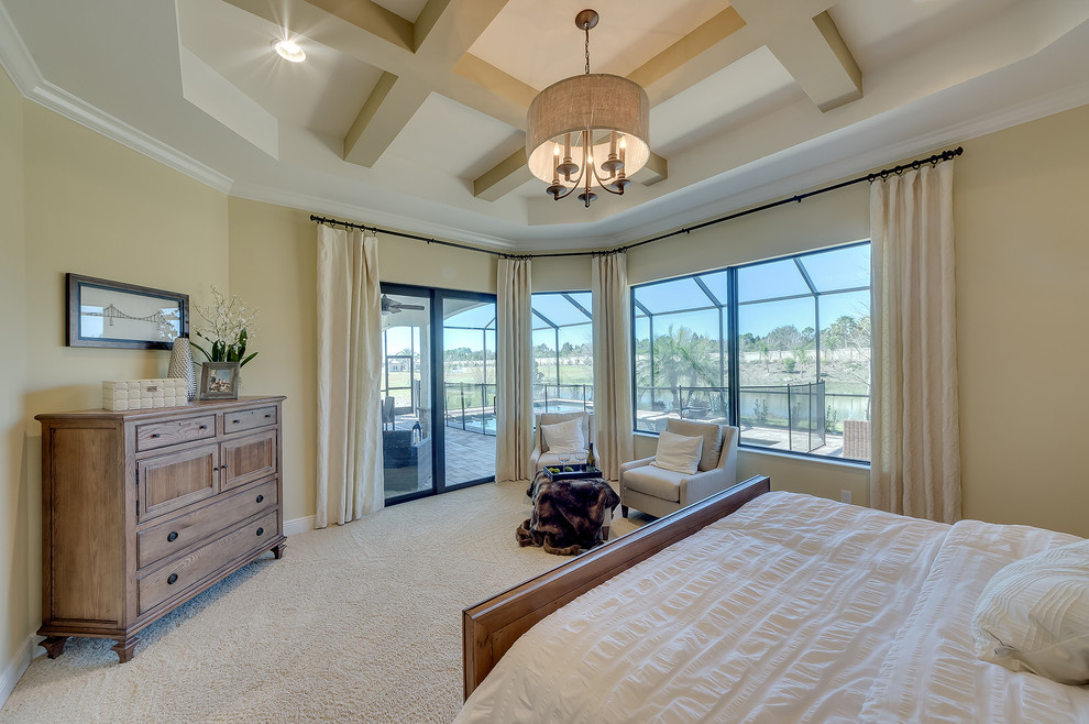 This is an example of a large contemporary master bedroom in Tampa with beige walls and carpet.