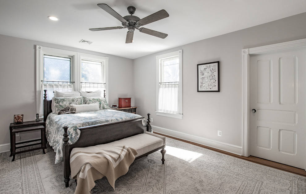 Ejemplo de dormitorio principal clásico grande sin chimenea con paredes grises, suelo de madera en tonos medios y suelo marrón