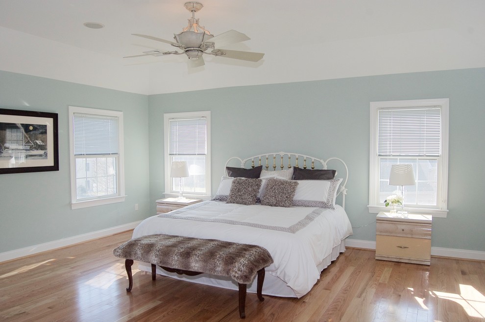 Aménagement d'une grande chambre parentale classique avec un mur bleu et un sol en bois brun.
