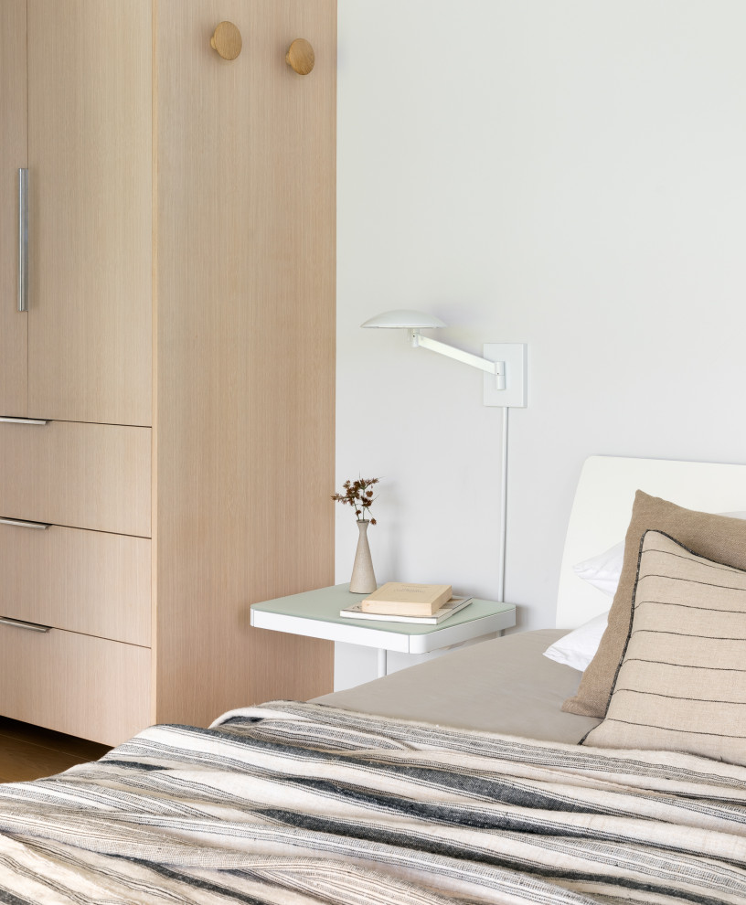 Ejemplo de dormitorio principal campestre pequeño con paredes blancas y suelo de madera clara
