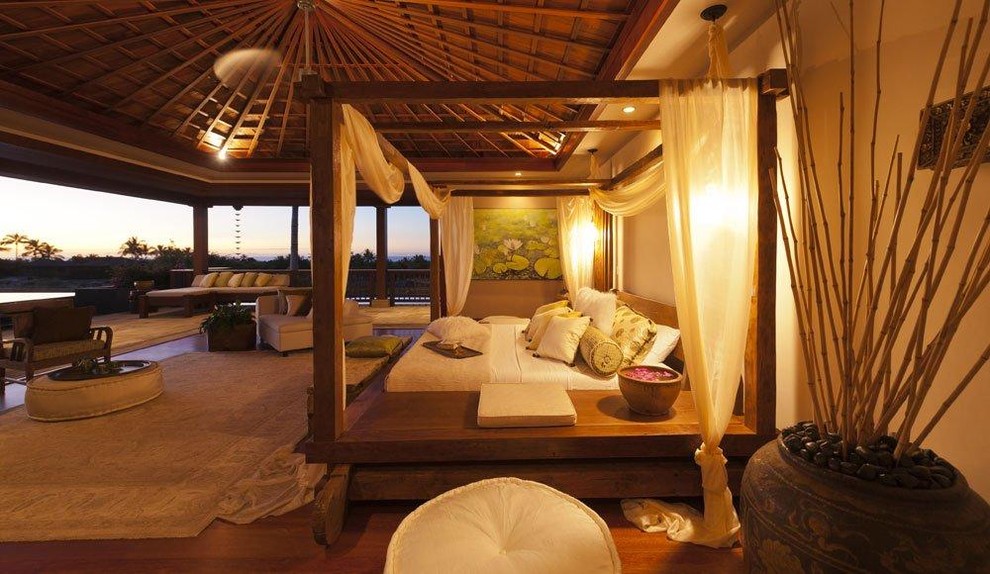 Foto di una grande camera matrimoniale tropicale con pareti beige, pavimento in legno massello medio e nessun camino