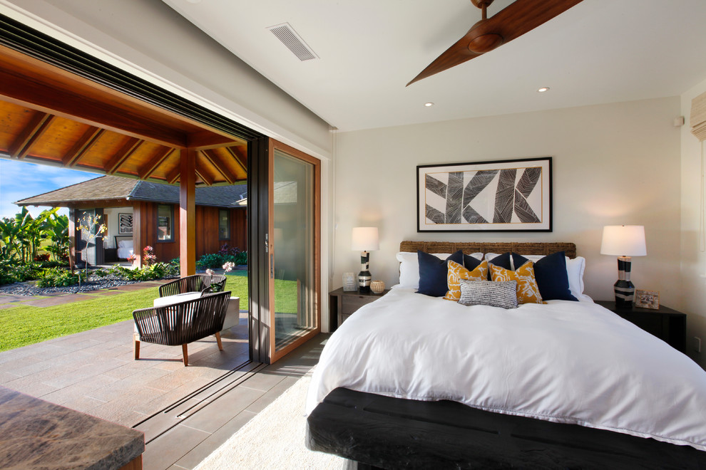 Esempio di una camera degli ospiti tropicale di medie dimensioni con pareti bianche e pavimento grigio