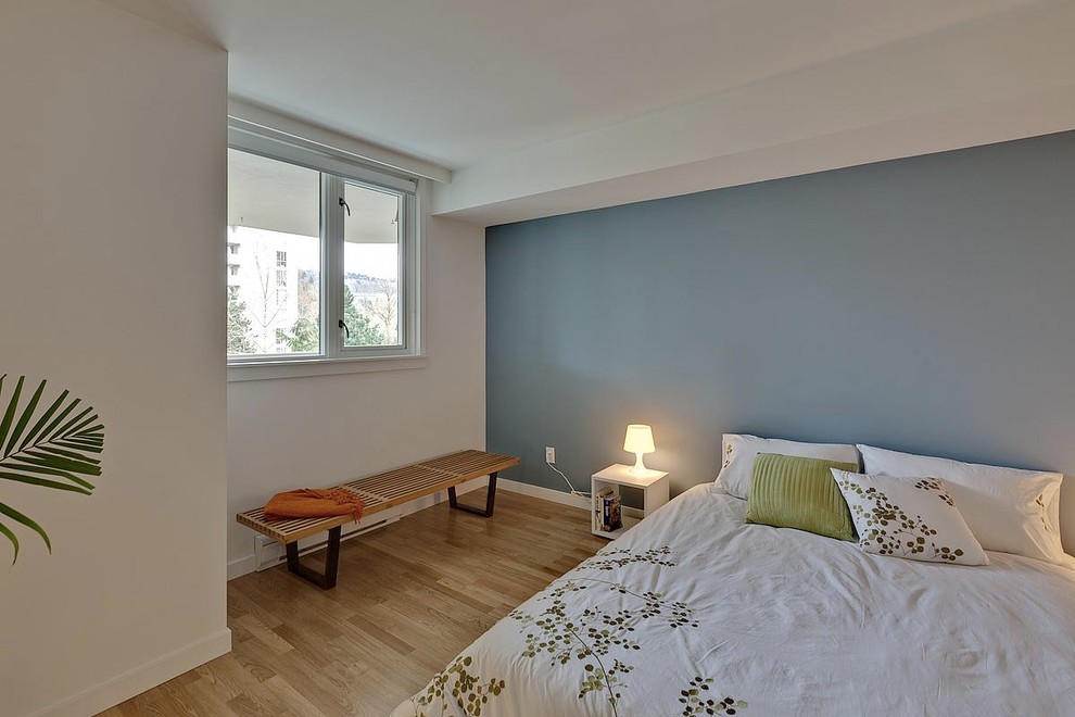 Inredning av ett modernt sovrum, med blå väggar och ljust trägolv