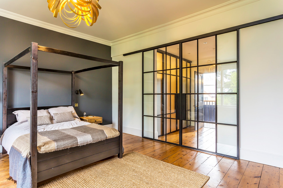Aménagement d'une chambre parentale contemporaine de taille moyenne avec un mur multicolore, un sol en bois brun et un sol marron.