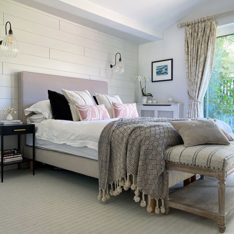 This is an example of a scandinavian master bedroom in Surrey with white walls and panelled walls.