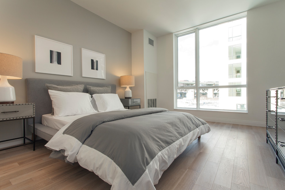 Foto de dormitorio principal moderno de tamaño medio con paredes blancas, suelo de madera clara y suelo beige