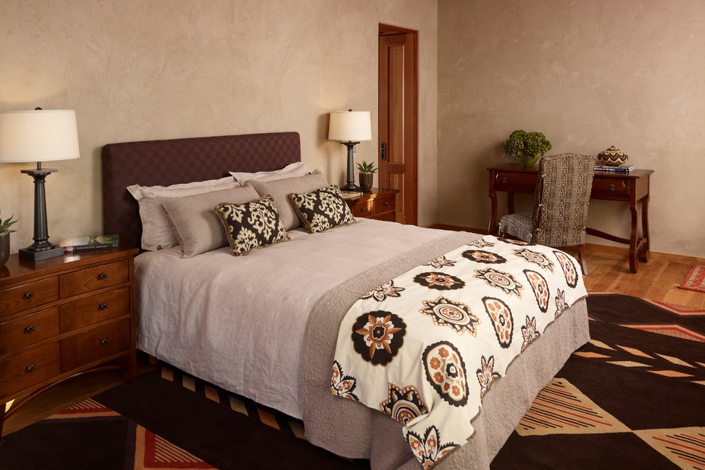 Esempio di una camera degli ospiti american style con pareti beige e parquet chiaro