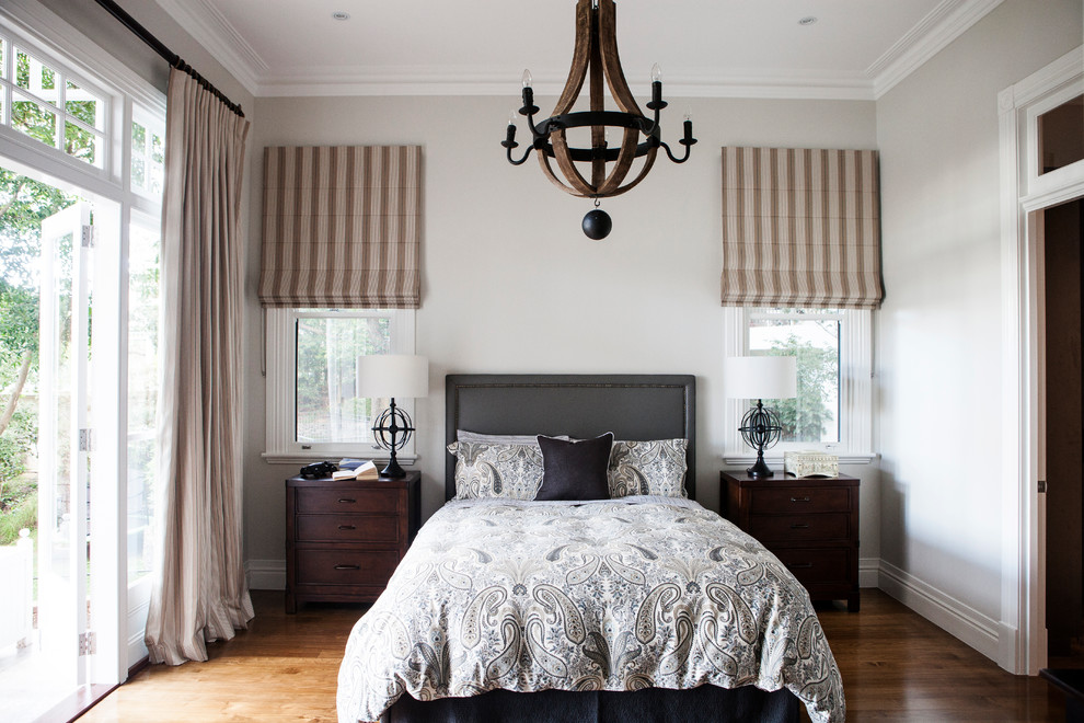 Ispirazione per una camera da letto chic di medie dimensioni con pareti bianche e pavimento in legno massello medio