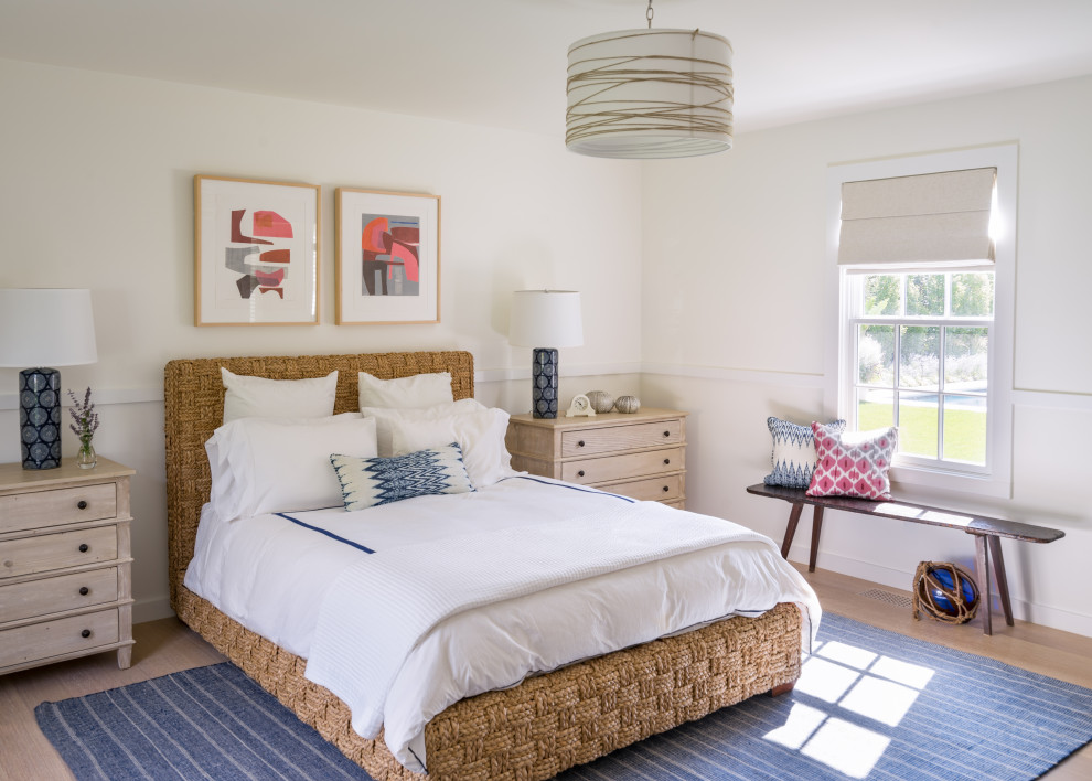 Foto di una camera da letto costiera con pareti bianche, pavimento in legno massello medio e pavimento marrone