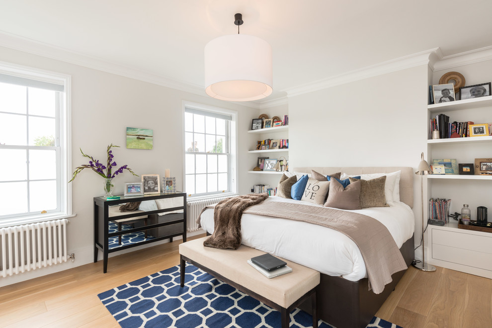 Bedroom - transitional master light wood floor bedroom idea in London with beige walls