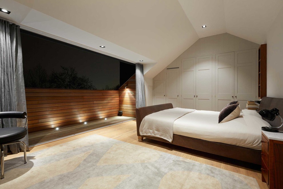 Inspiration for a medium sized modern master bedroom in London with grey walls and light hardwood flooring.