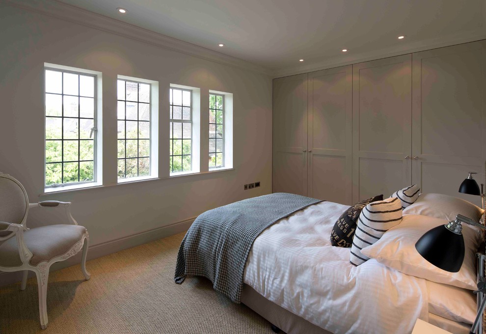 Mid-sized elegant guest carpeted and beige floor bedroom photo in London with beige walls