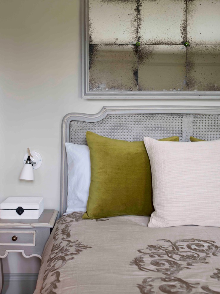 This is an example of a medium sized classic guest bedroom in London with green walls, carpet and beige floors.