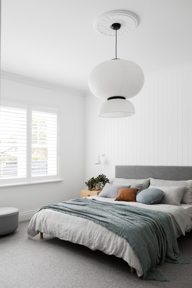На фото: хозяйская спальня в современном стиле с белыми стенами, ковровым покрытием, стандартным камином, фасадом камина из плитки и серым полом