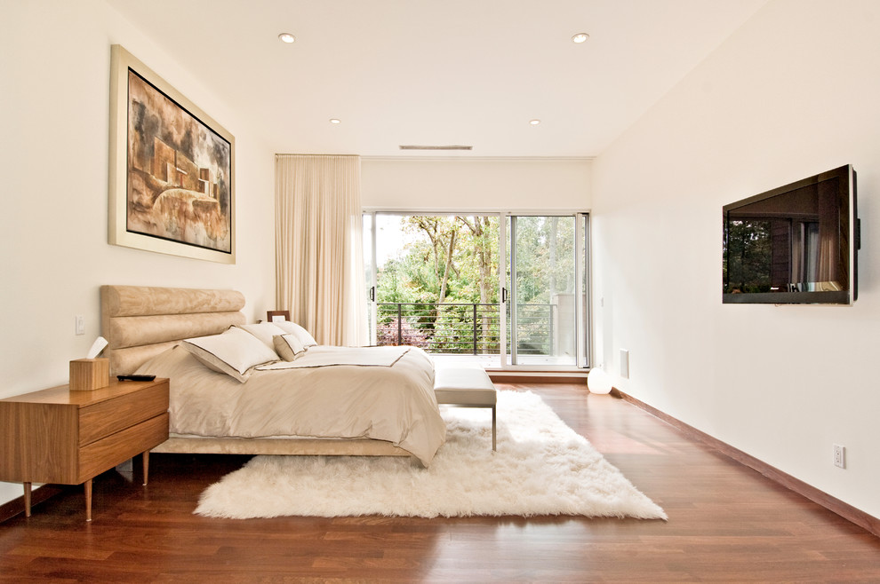 Modern bedroom in New York with white walls and medium hardwood flooring.