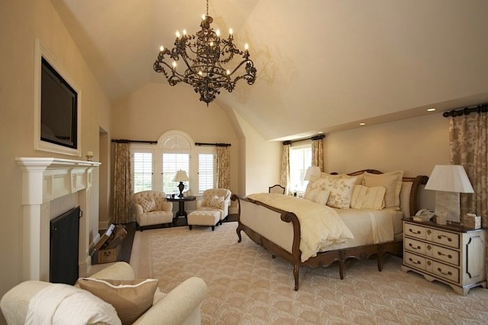Cette image montre une grande chambre traditionnelle avec un mur beige, une cheminée standard et un manteau de cheminée en pierre.