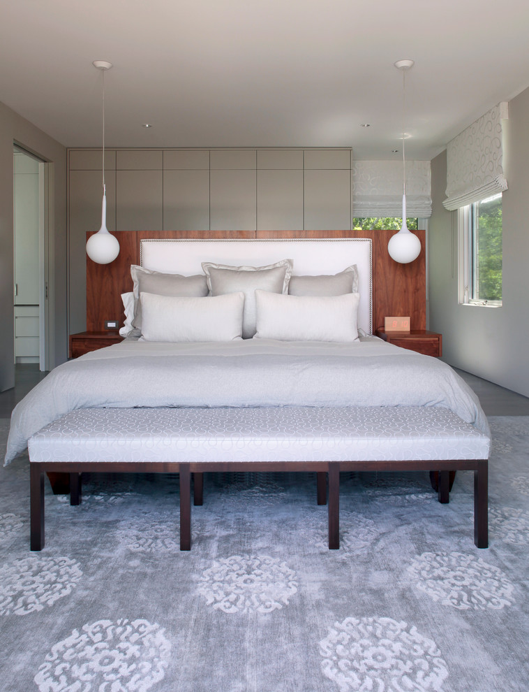 This is an example of a medium sized contemporary master bedroom in New York with grey walls, no fireplace and carpet.