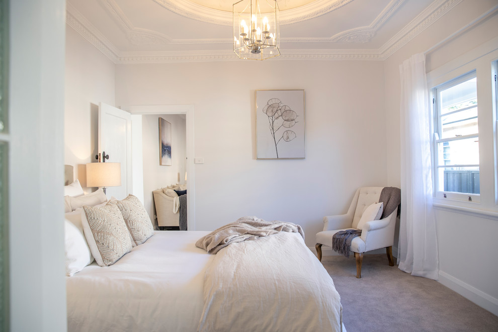 Imagen de dormitorio principal costero con paredes blancas, moqueta y suelo beige
