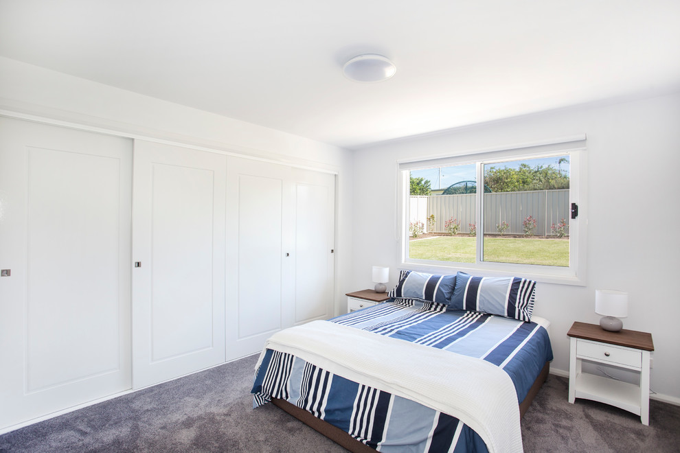 На фото: маленькая спальня в морском стиле с белыми стенами, ковровым покрытием и серым полом без камина для на участке и в саду