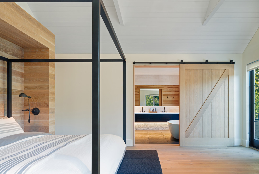 Modelo de dormitorio campestre con paredes blancas y suelo de madera en tonos medios