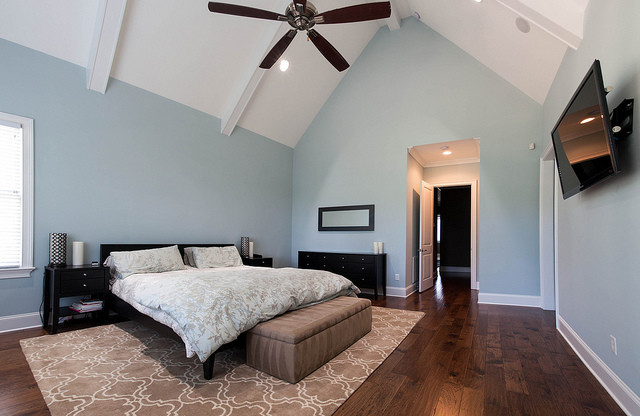 Diseño de dormitorio rústico con paredes azules y suelo de madera oscura