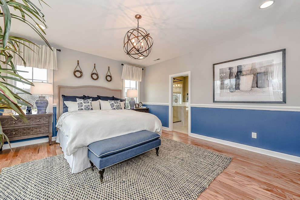 Mid-sized cottage master light wood floor bedroom photo in Charlotte with blue walls