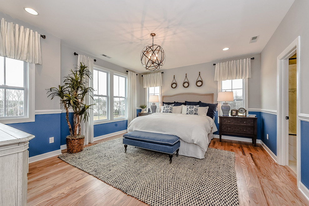 Imagen de dormitorio principal campestre de tamaño medio sin chimenea con paredes azules y suelo de madera clara