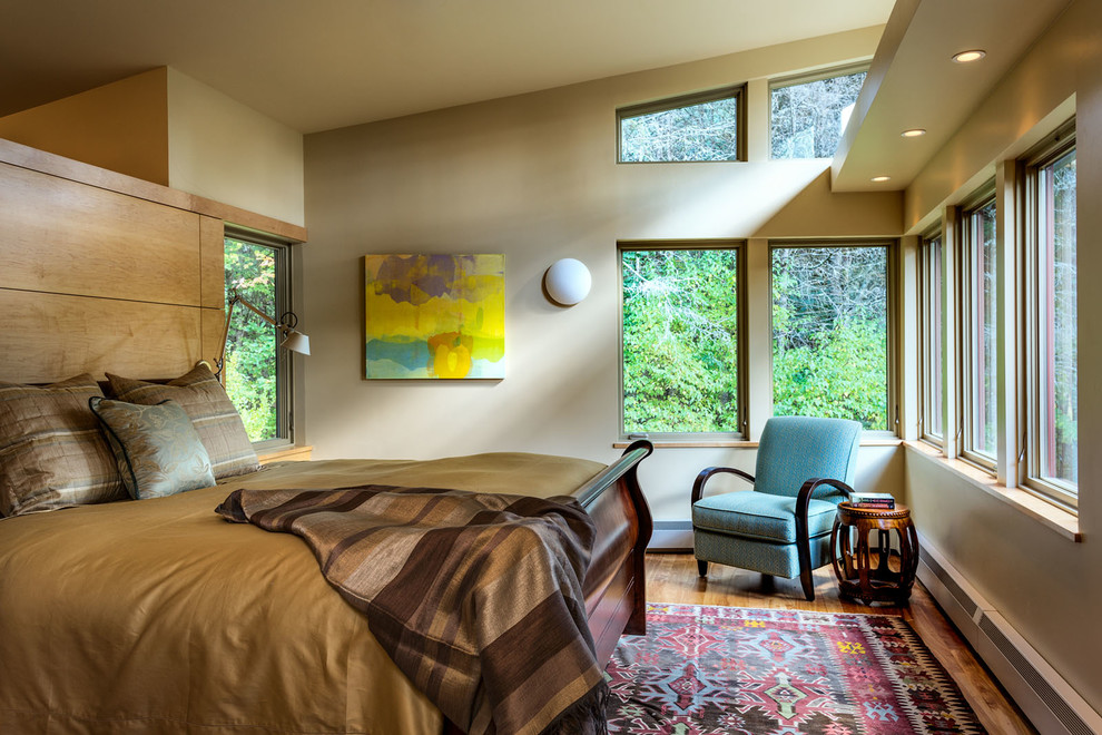 Cette image montre une chambre design avec un mur beige et un sol en bois brun.