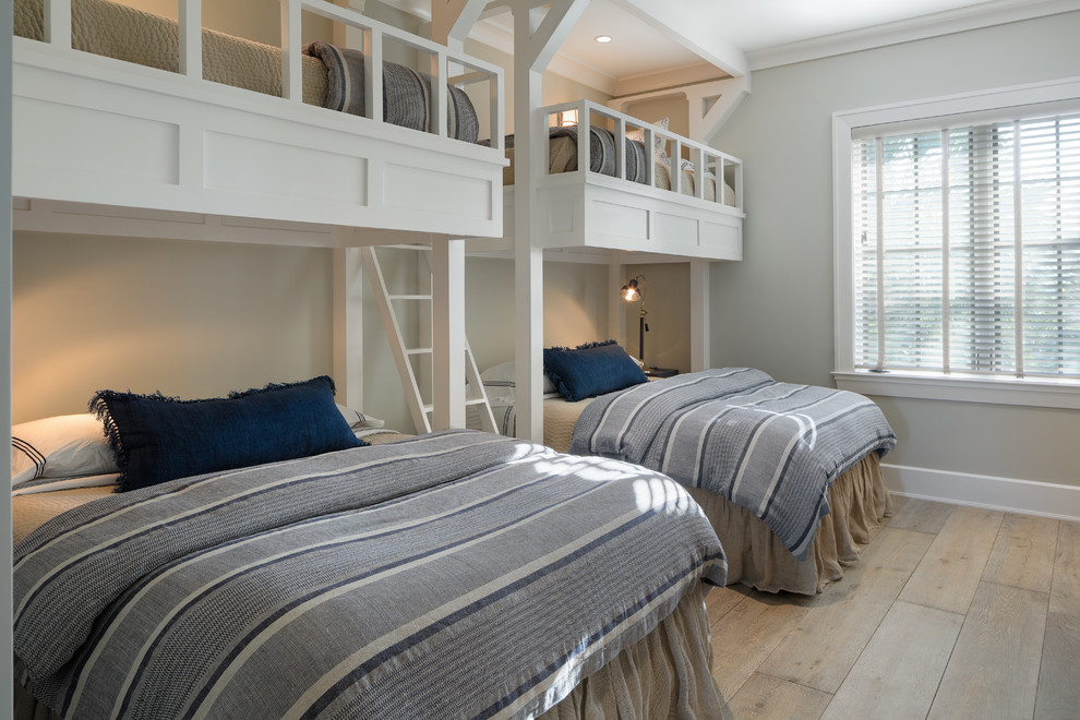 Coastal guest bedroom in Tampa with grey walls, light hardwood flooring and beige floors.