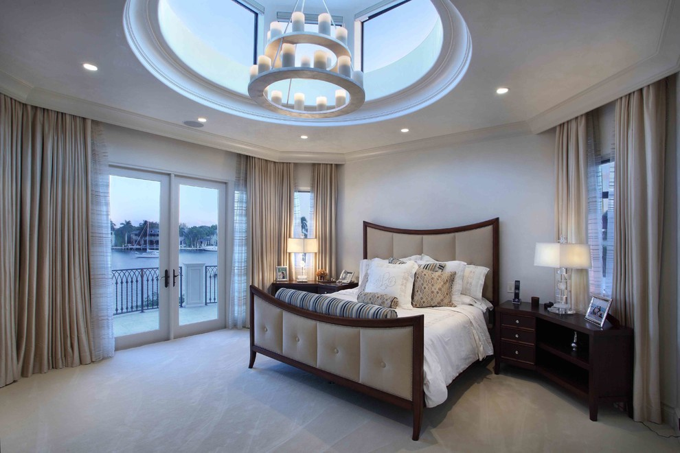 Design ideas for an expansive mediterranean master bedroom in Miami with beige walls, carpet, grey floors and feature lighting.
