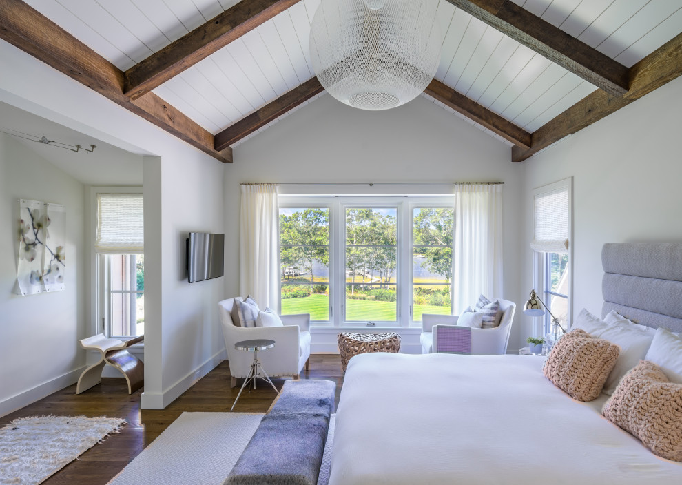 Ejemplo de dormitorio costero con paredes blancas, suelo de madera en tonos medios y suelo marrón